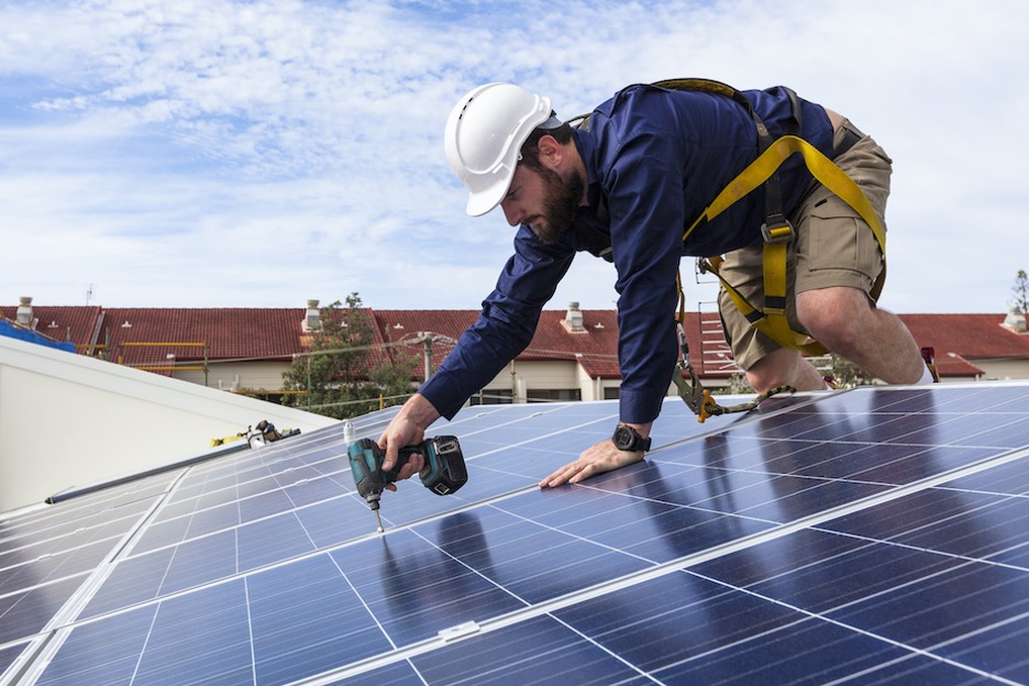 Solar energy technician works on a solar panel