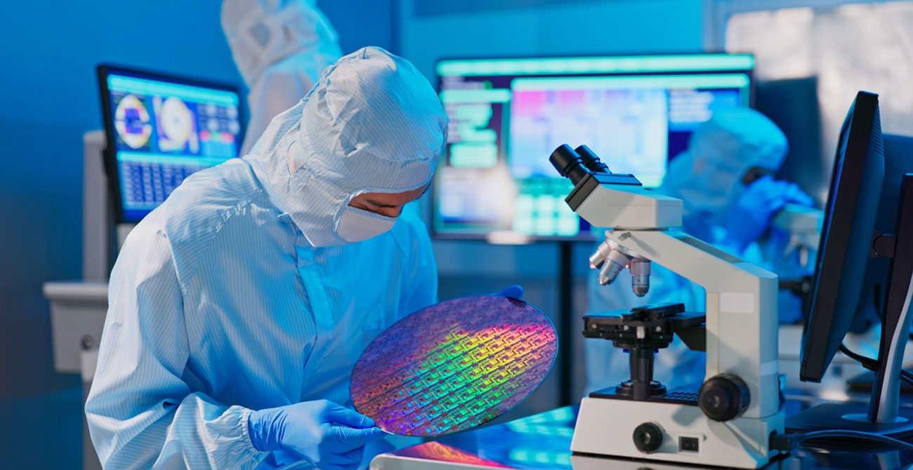 semiconductor technician in a clean suit works on a colorful chip in a lab