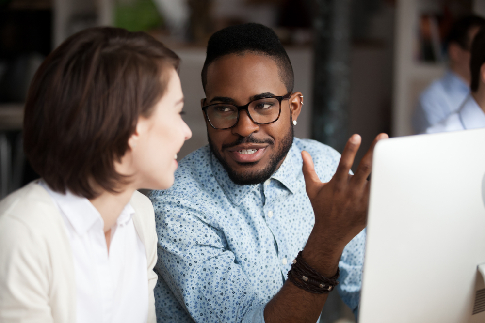 Two people in office setting learning new technology, reskilling