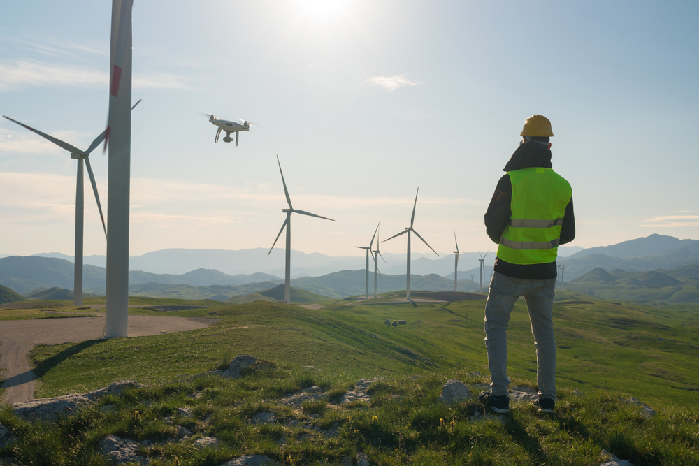 Wind turbine technician uses a drone to check on turbines, example of benefits of wind turbine technician training