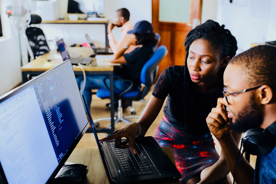 A woman shows a male trainee how a computer program works