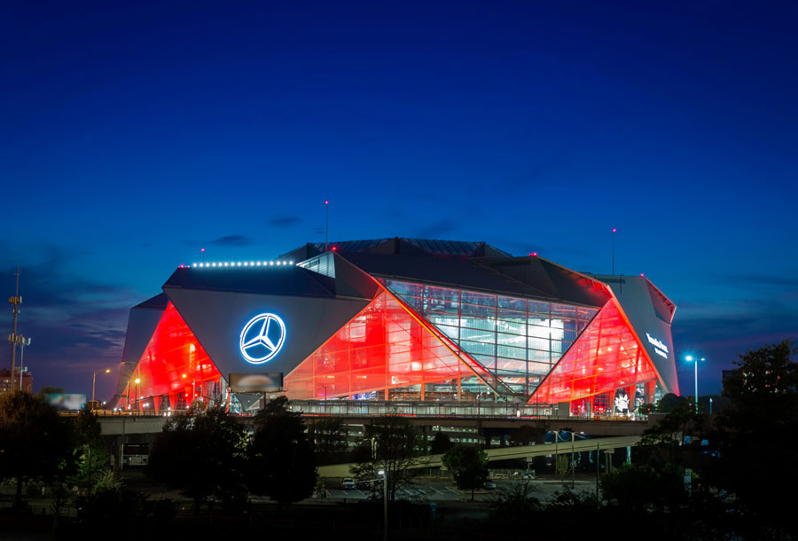 Mercedes-Benz Stadium lit up at night in Atlanta for a Falcons or Atlanta United game