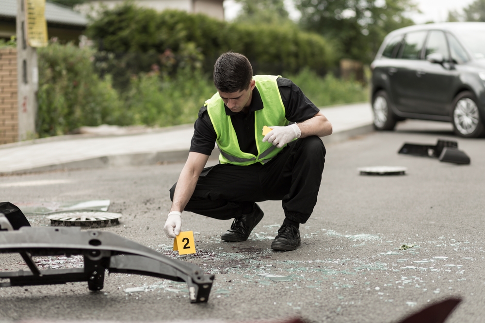Police officer in safety vest investigates the scene of a car accident, example of how to become a police officer