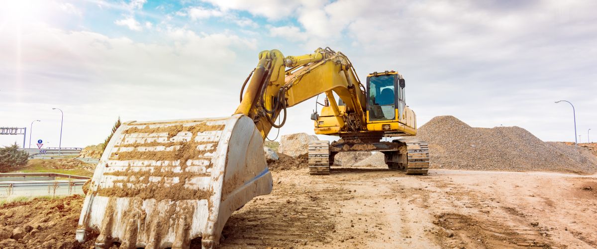 A construction equipment operator will manage an excavator to clear the way for a new road