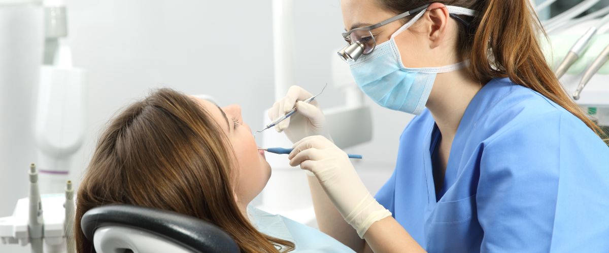 A dental hygienist cleans a patient’s teeth