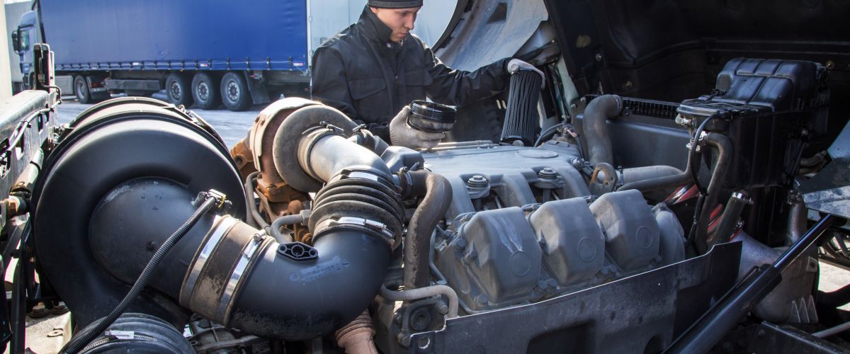 Diesel mechanic inspects a truck engine