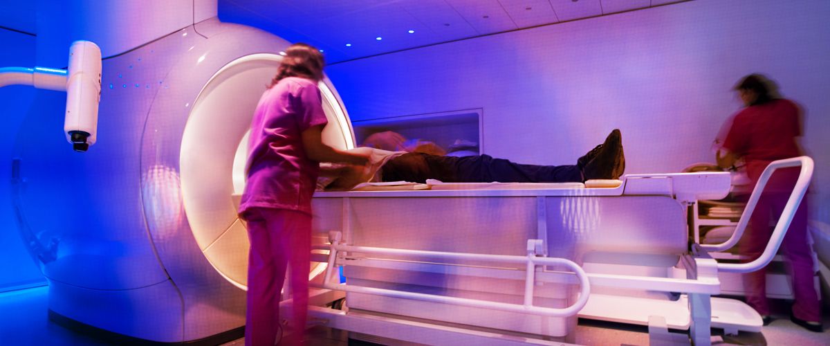 MRI technicians prepare a patient for a scan