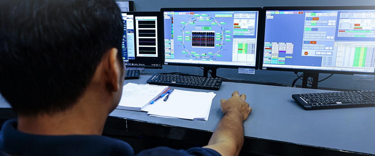 A nuclear technician monitors screens in the control room. 