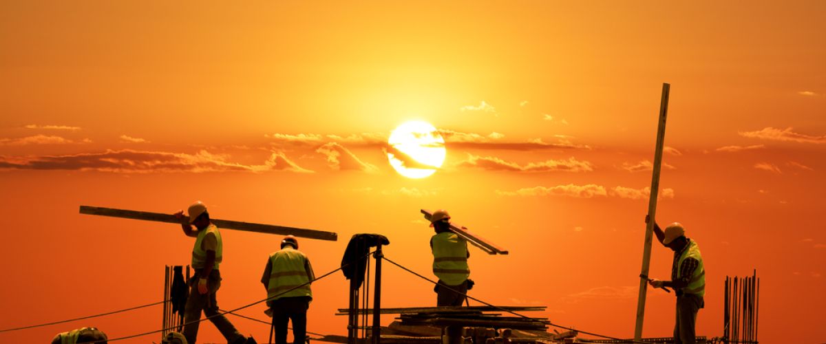 Sun sets over a construction site, representing infrastructure jobs