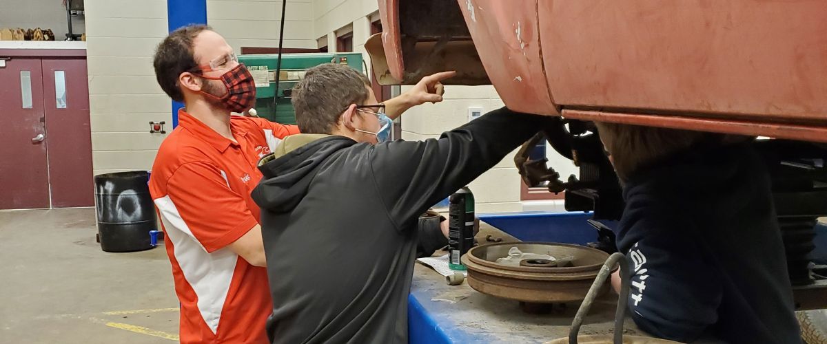 Drake Davis, diesel mechanic and instructor, works with a student to install king pins and spindles on a F100 Truck
