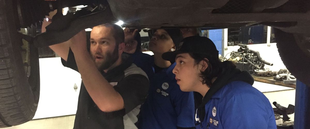 Auto mechanic Jake Sorensen shows technicians how to fix something on a car