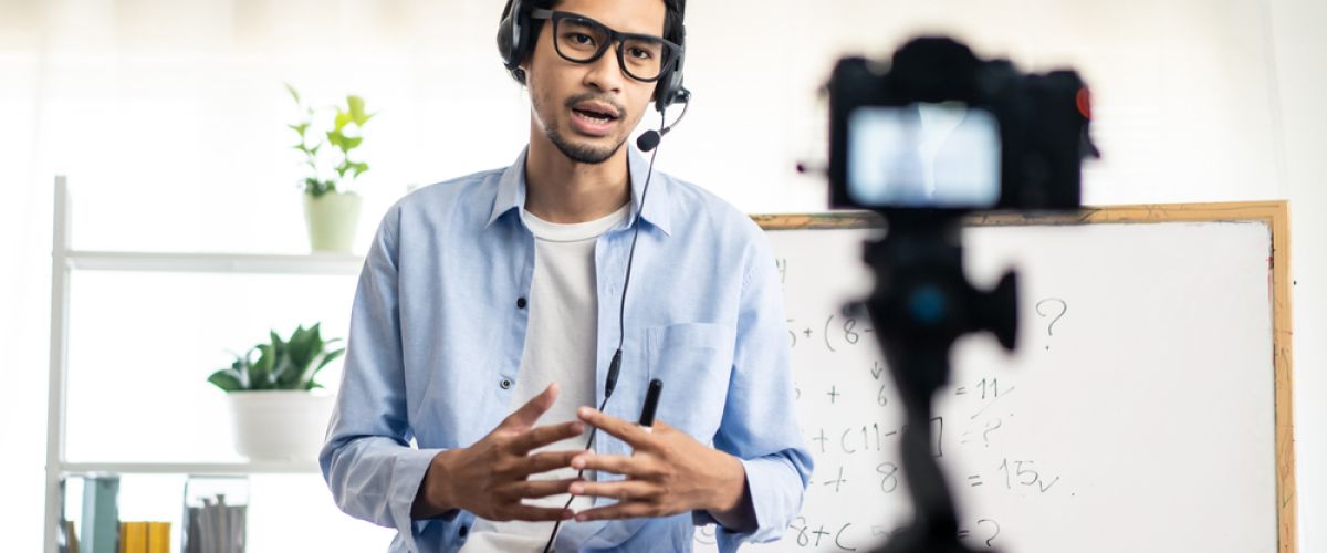 Instructor with headphones teaches remotely, importance of AV technicians to online learning