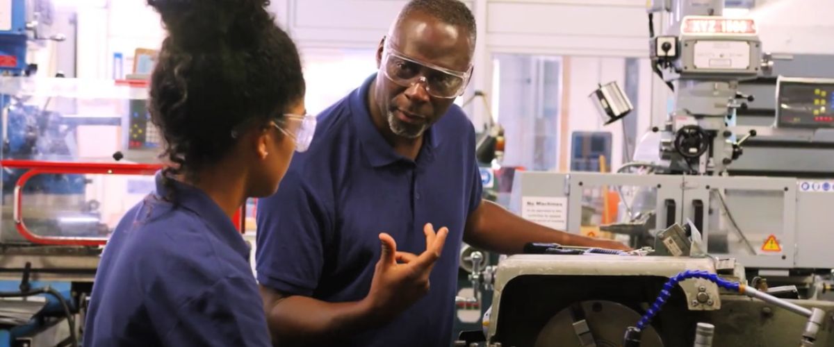 Man teaches woman how a piece of equipment works, XPRIZE Rapid Reskilling