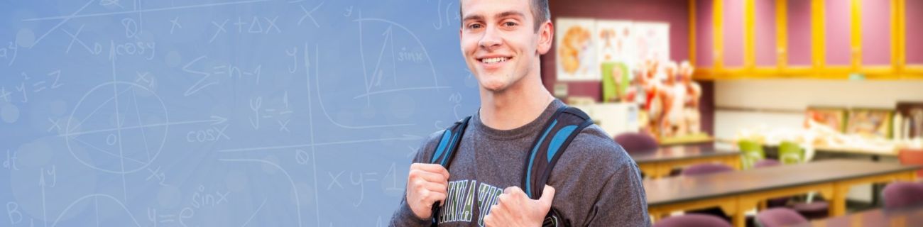 student with chalkboard and classroom behind him 