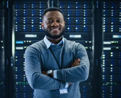 Black man in front of bank of computer servers