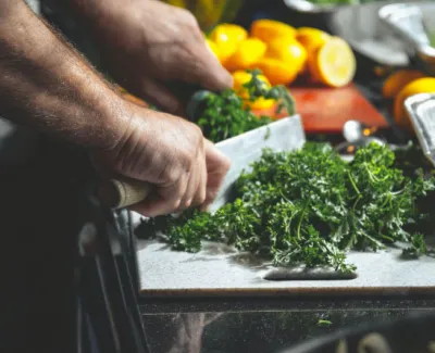 Chef hands chopping greens and vegatables
