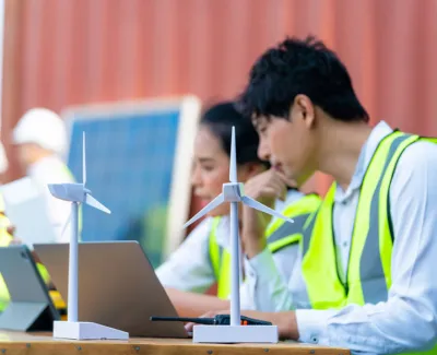 Wind turbine techs at table with turbine model