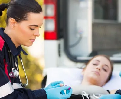 Two EMTs assist a patient outside an ambulance
