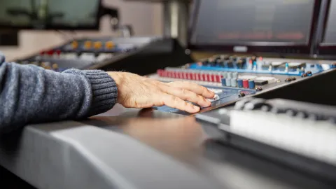 hand on a production console, role  of AV technician