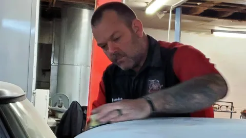 Brandon McCoy, auto body technician, works on improving the roof of a car