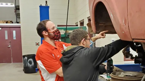Drake Davis, diesel mechanic and instructor, works with a student to install king pins and spindles on a F100 Truck