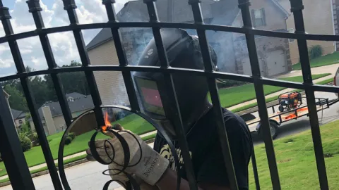 Eddie Hines, metal fabricator working on a fence