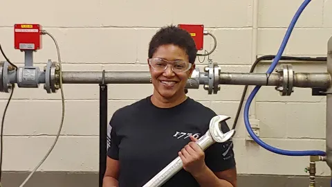 Electrical and electronics engineering technician Tracy Wilson with a large wrench