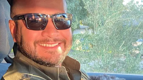 Officer Javier Arteaga with a puppy in his squad car