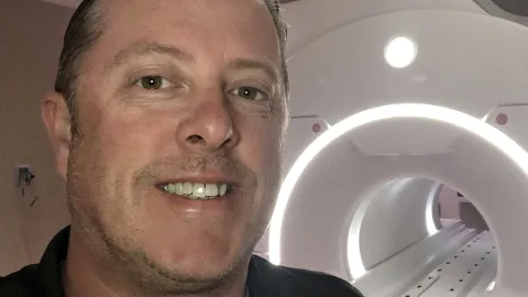 Joseph Seibert, MRI tech ambassador, stands in front of an MRI machine