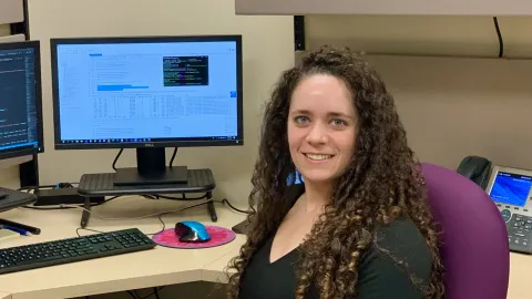 Software developer Rachel Meltzer sits in front of her computer screens