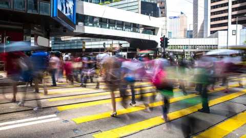 People walk in a crosswalk on a busy day