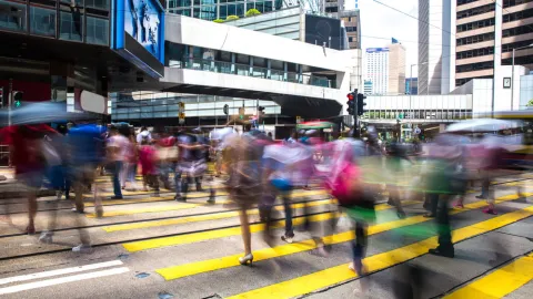People walk in a crosswalk on a busy day