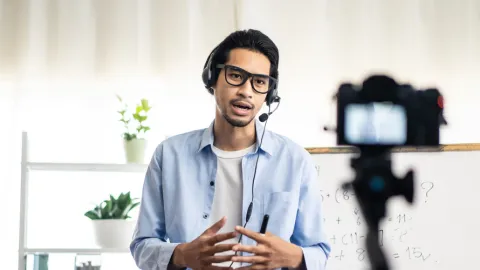 Instructor with headphones teaches remotely, importance of AV technicians to online learning