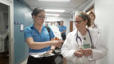 Two FSCJ nursing students walk together down a hospital hallway.