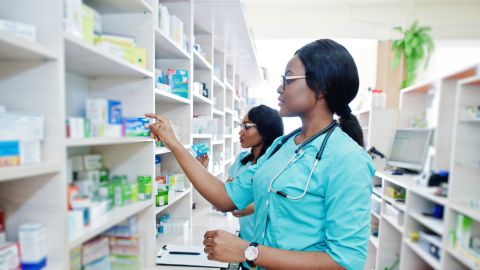 two Black female pharmacy technicians work in a pharmacy, example of pharmacy technician training