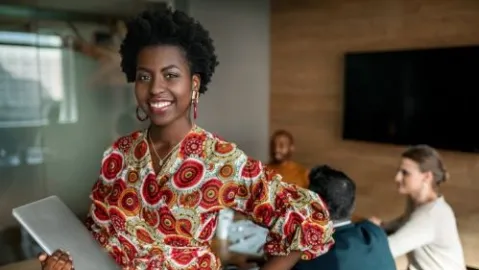 Confident black professional holding computer