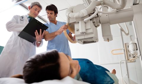 A radiology tech consults with a doctor before scanning a patient