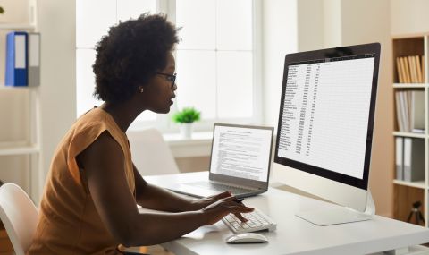 Young black female bookkeeper works on a computer crunching numbers
