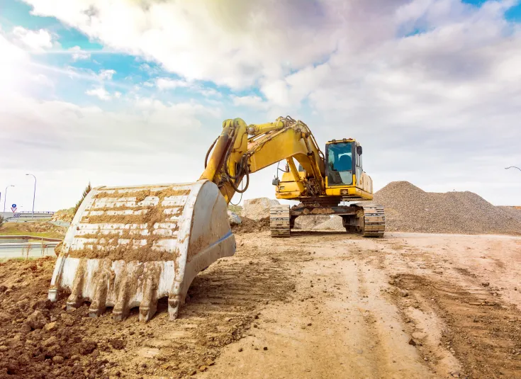 A construction equipment operator will manage an excavator to clear the way for a new road