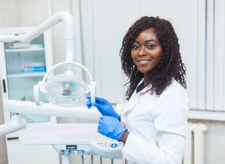 A dental assistant prepares dental equipment for a procedure