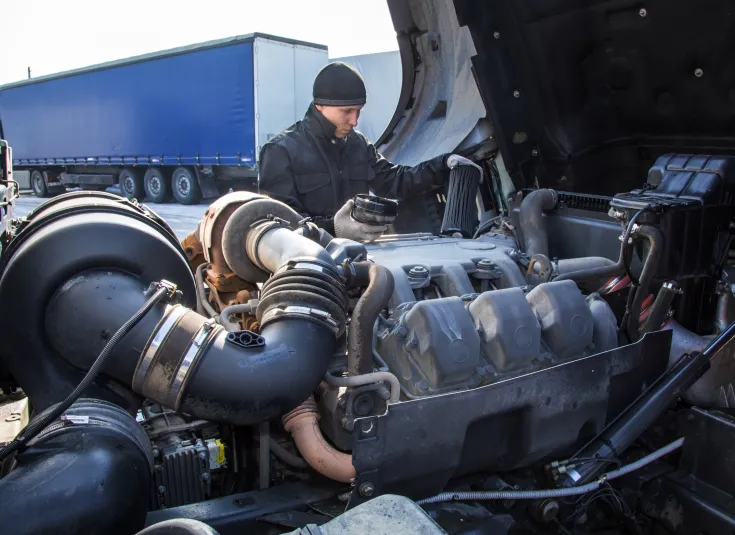 Diesel mechanic inspects a truck engine