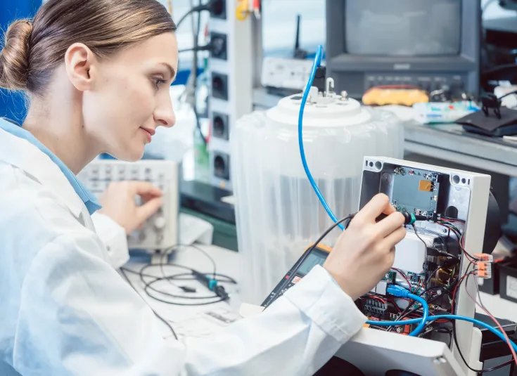 An electronics engineering technician tests a product in a lab for EMC compliance