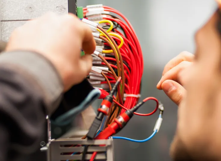 An electrician installs wiring