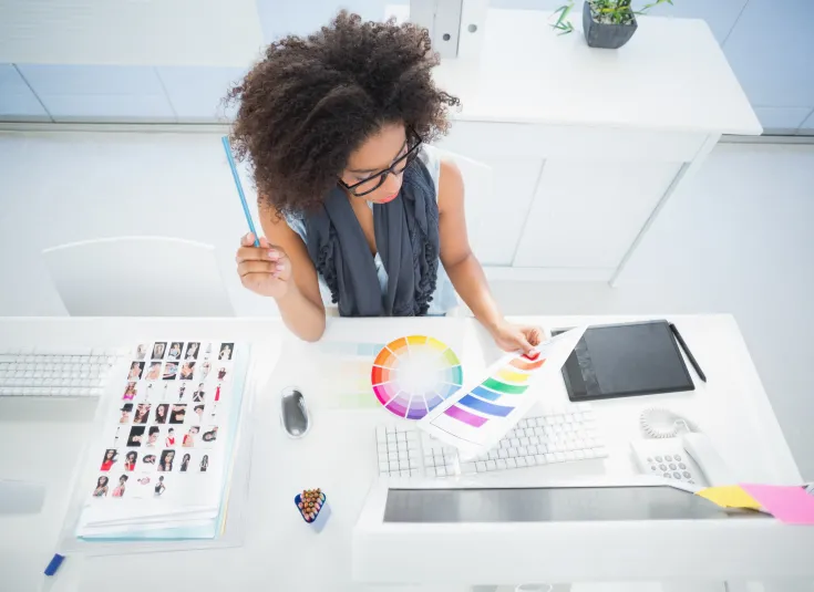 A graphic designer studies a color palette at her desk