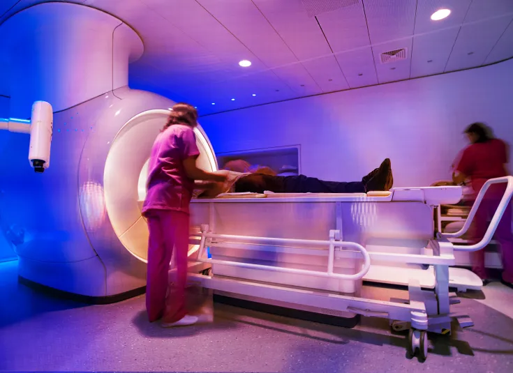 MRI technicians prepare a patient for a scan