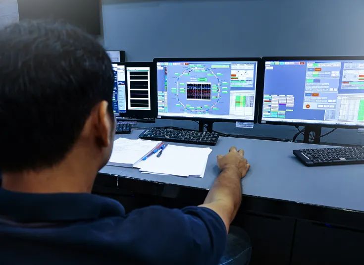 A nuclear technician monitors screens in the control room. 