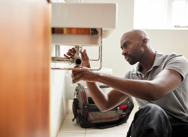 A plumber replaces a pipe fitting