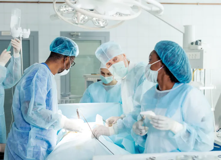 A surgical technologist works in an operating room with the surgical team