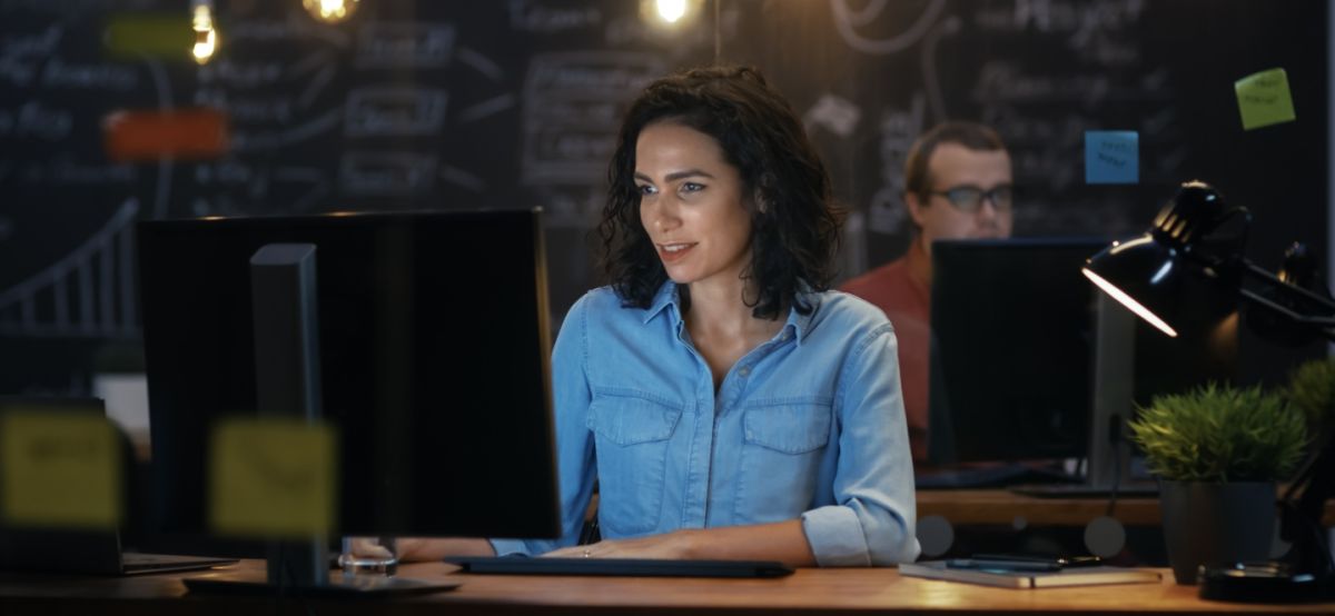 Female IT professional sits at computer