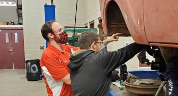 Drake Davis, diesel mechanic and instructor, works with a student to install king pins and spindles on a F100 Truck